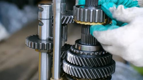 Mecânico montando um sistema manual de transmissão de caixa de câmbio de carro