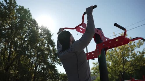 A Man Does Pullups on a Horizontal Bar