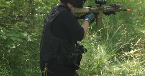 Tactical guy walking in forest while looking down his sights