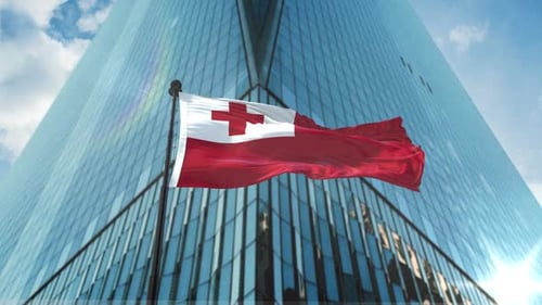 Tonga Flag Waving in Front of Modern Corporate Building