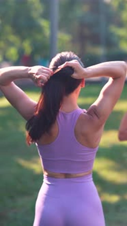 A Mother and Her Grown Daughter Both Sporty and Beautiful are Practicing Yoga in the Urban Park