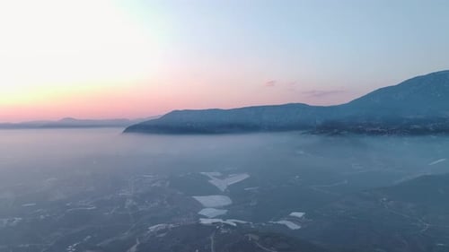 Aerial View Fog Over the City at Sunset Soft Light and Misty Skies