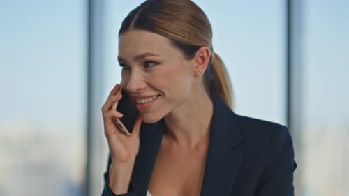 Smiling Woman Talking on Phone in Modern Office