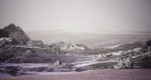 Vast Barren Landscape with Rocky Formations Under a Foggy Sky at Dusk