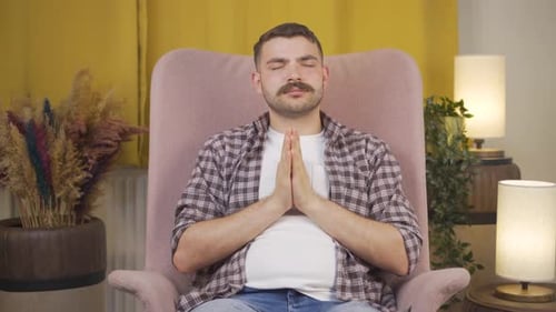 Relaxed Young Adult Meditating in Armchair