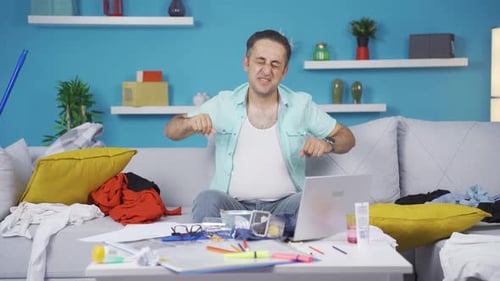 Tired Man Stretching on Couch in Messy Room