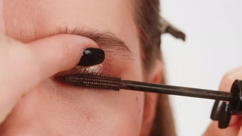 Woman Applying Brown Mascara to Eyelashes Close-up