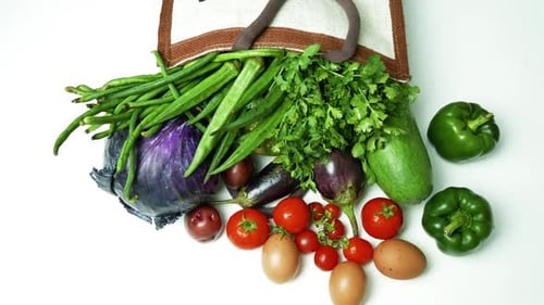 Verduras en bolsa reutilizable, una variedad de verduras frescas que salen de una bolsa reutilizable