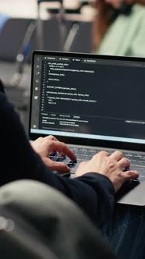 Vídeo vertical digital Nomad Man programando em laptop em aeroporto internacional