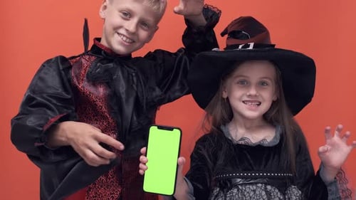 Children in Costumes Displaying Phone with Green Screen