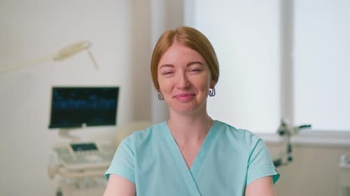 smiling gynecologist doctor in gynecological office near ultrasound and gynecological chair waiting