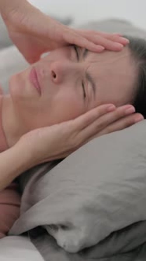 Woman Lying in Bed Suffering with Headache