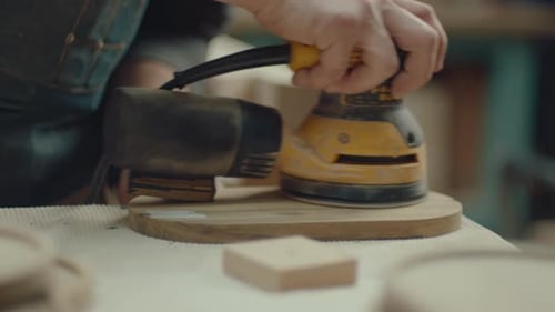 Man Sands Wooden Board With Power Sander