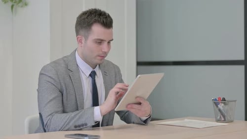 Young Businessman using Digital Tablet for Work