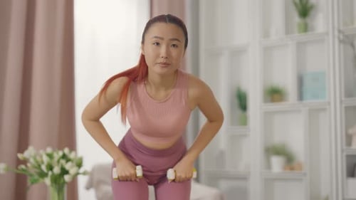 Woman Exercising with Dumbbells Indoors