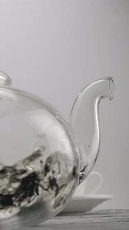 Pouring Water into Tea Pot with Tea Leaves