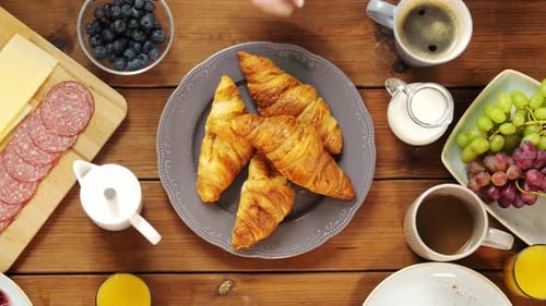 Food, Eating and People Concept - Top View of Hands Taking Croissants