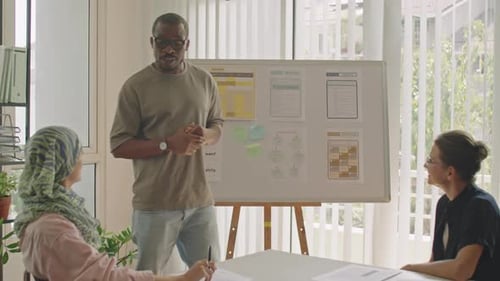 Black Male Teacher Talking by Whiteboard during Lesson