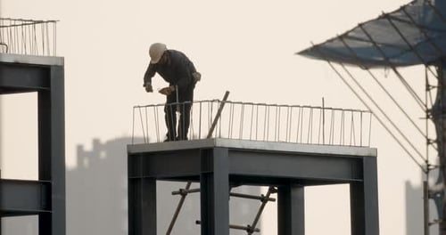 Chinesischer Arbeiter schnürt Bewehrung