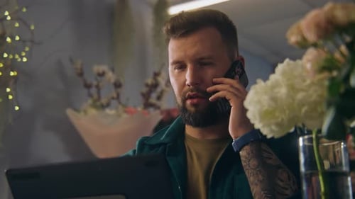 Male Entrepreneur Florist in Flower Store Talks By Phone