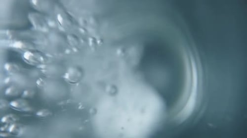 White Tablet Dissolving in Water Close Up
