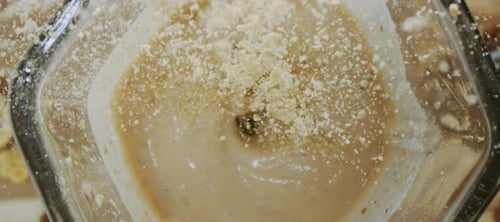 Pouring protein powder into milkshake