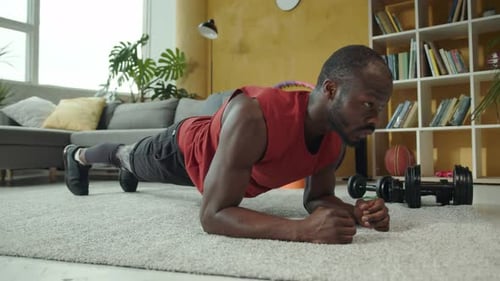 Muscular Man Doing Plank Exercise at Home