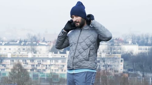 Young Man Using Smartphone and Start Jogging in City Park Adult