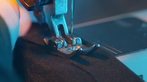 Sewing Machine Stitching Dark Fabric in Close Up