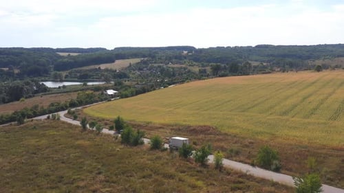 Aerial Shot of Truck with Cargo Trailer Driving on Empty Road and Transporting Goods Flying Over