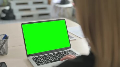 Young Businesswoman Working on Laptop with Chroma Key Screen