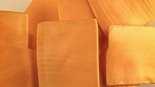 Des tranches de cheddar volent et tombent filmées par une caméra à haute vitesse à 1000 images par seconde