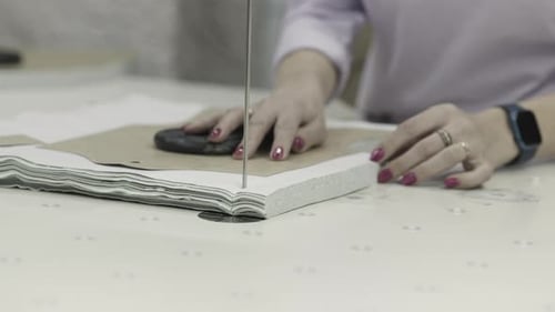 A Skilled Tailor Cuts Fabric with a Bandsaw for Precise Tailoring Outcomes in the Workshop