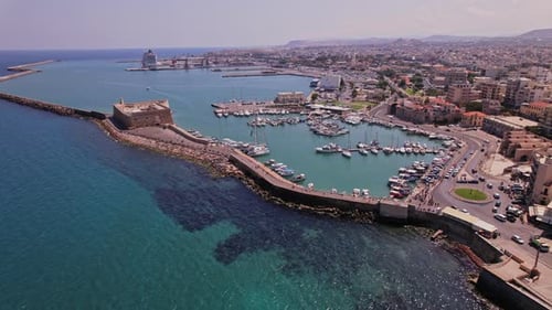 Aerial view of a lively harbor in a coastal town during sunny weather