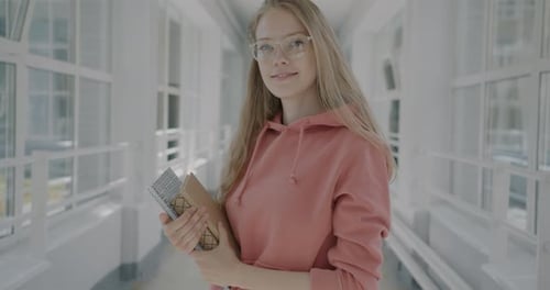 Slow Motion Portrait of Smart Female Student Standing in College Hall Holding Books Smiling