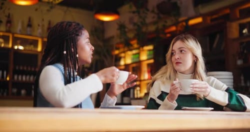 Women, coffee and conversation in cafe as friends with chat, gossip and funny news for social