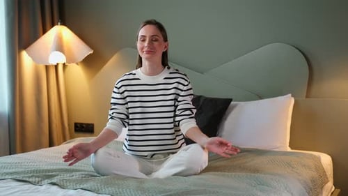 Woman Meditating on Bed in Peaceful Bedroom