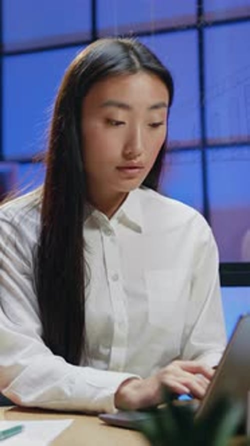 Woman Works at Computer in Urban Office at Night