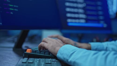 Nahaufnahme von Programmierer-Händen, die nachts auf der Tastatur tippen