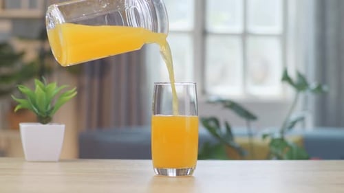 Pouring Fresh Orange Juice Into a Glass