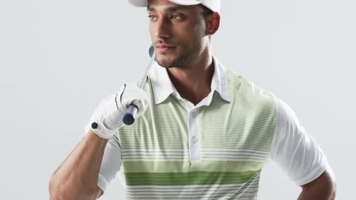 Confident Young Male Golfer Posing with Club in Studio
