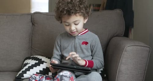 A small boy plays a game on a tablet. Third of four clips.
