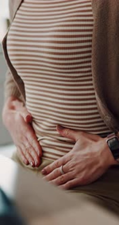 Hands, stomach ache and rub for relief in home with cramps, bloated and constipation in living room