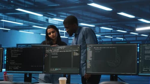 Multiethnic Team of Engineers in Data Center Uses Laptop to Do Programming