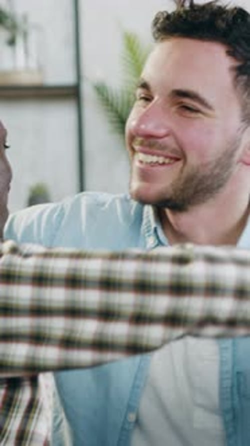 Two Young Men Embrace Each Other Indoors