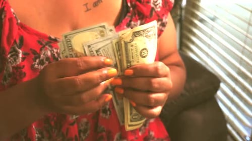Cropped view of female hands counting US dollar bills. Woman in red dress holding banknotes. Money,