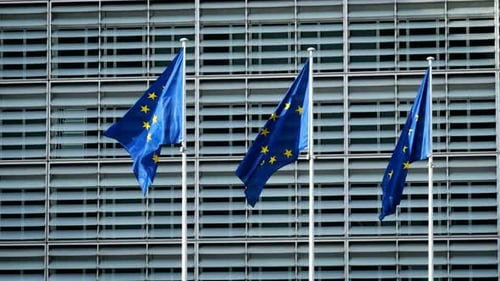 European Union Flags Waving Against Modern Office Building