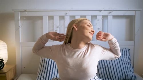 Woman Stretching in Bed in the Morning