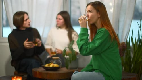 Students Talk and Relax in Cozy Cafe Media Beautiful Young Woman is Drinking Tea on Background of