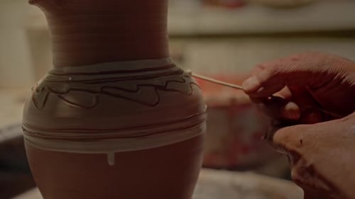 Potier en train de décorer le pot en argile, sculpteur professionnel peignant sa cruche en céramique